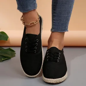 Vooraanzicht van zwarte canvas espadrilles met touwzool en veters.
