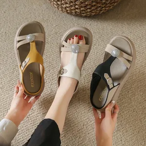 Detailansicht modischer Plateau-Sandalen mit Strasssteinen für Damen in Gelb Weiß und Schwarz.