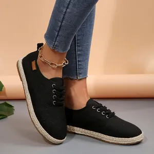 Klassieke zwarte canvas espadrilles voor dames met platte gevlochten strozolen.