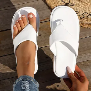 Detalle en primer plano de chanclas blancas con plataforma en una terraza de madera
