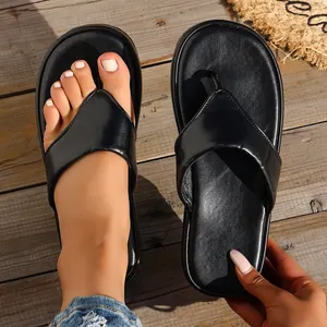 Elegantes sandalias de plataforma negras para mujer sobre una cubierta de madera