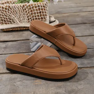 Primer plano de chanclas con plataforma marrones para mujer con acabado en cuero liso.