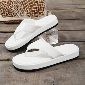 Detalle lateral de sandalias de plataforma blancas para mujer con suela negra