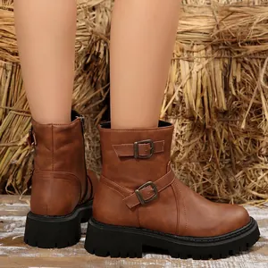 Detail of brown vintage Martin boots with buckle straps and a thick black lug sole.