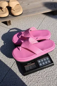 Primer plano de chanclas con plataforma rosa ligeras en una báscula digital de 270,0 g