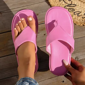 Vista detallada de elegantes sandalias de dedo con plataforma rosa sobre madera