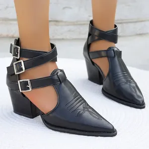 Détail de bottines romaines noires à bout pointu, talon épais et triples boucles élégantes