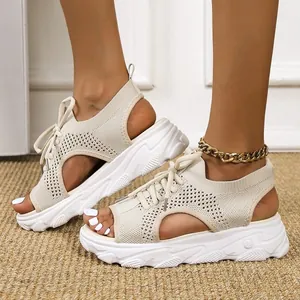 Primer plano de sandalias de plataforma de punto beige con cordones y punta abierta