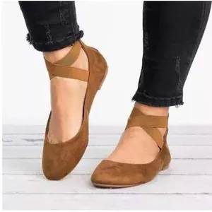 Close-up view of vintage brown suede ballet flats featuring elastic cross ankle straps