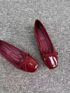 Dettaglio di ballerine bordeaux stile francese con punta squadrata e fiocco decorativo.