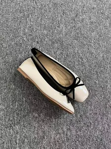 Vista dettagliata delle ballerine beige a punta quadrata con fiocco e bordo neri.