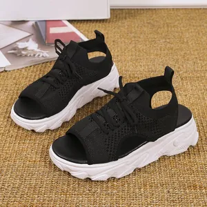 Detalle de las sandalias de plataforma de punto negro con cordones y punta abierta