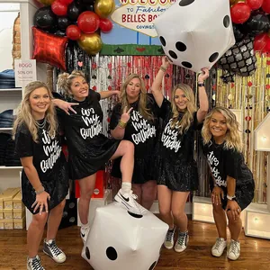 Group of women wearing matching black sequin birthday dresses with ruffled hems