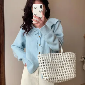 Detail of light blue knit cardigan with doll collar and bow tie detail