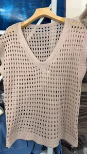 Primer plano del chaleco de punto beige con cuello en V y textura de malla calada