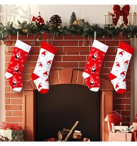 Decorative set of four knitted Christmas stockings with gnome patterns by a fireplace