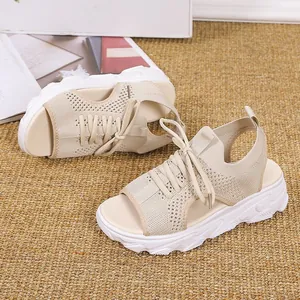 Detalle de las sandalias de plataforma de punto beige con cordones sobre una alfombra