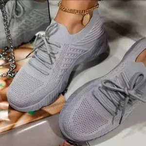Close-up of grey breathable fly-knit mesh sneakers for women in sports casual style.
