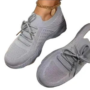 Breathable light grey fly-knit sneakers for women featuring a stylish lace-up design.