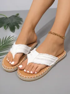 Detaillierte Ansicht weißer Zehentrenner mit Fransen und Espadrille-Sohlen-Stickerei