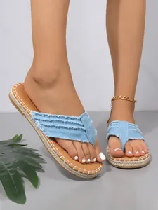Nahaufnahme modischer hellblauer Denim-Flip-Flops mit ausgefransten Kanten und weißen Nähten.