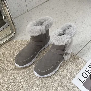 Détail des bottines d'hiver grises avec doublure en fausse fourrure et boucle décorative.