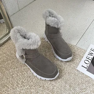 Vue détaillée de bottes d'hiver grises avec fourrure pour femme sur un tapis tissé