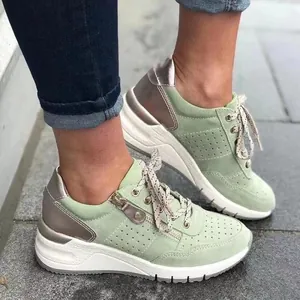 Detail view of stylish light green women's platform sneakers with metallic accents