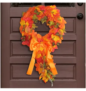 Detail view of autumn maple leaf wreath with a vibrant orange satin bow accessory.