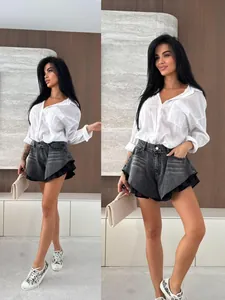 Vista dettagliata degli shorts in denim lavato da donna a vita alta con orlo a balze