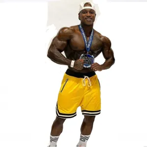 Inquadratura di un modello fitness con pantaloncini da basket in rete gialla traspirante