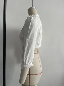 Dettaglio laterale di una camicetta corta bianca vintage francese con maniche a sbuffo