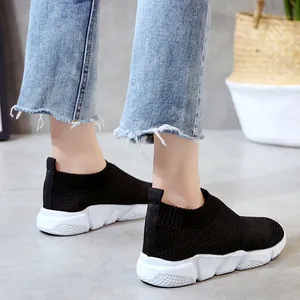 Detail view of black breathable fly-knit sneakers with chunky white sole