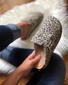 Vue détaillée de sabots mules à motif léopard avec une boucle et des bords effilochés.