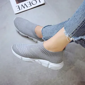 Close-up side view of women's grey breathable fly-knit slip-on sneakers on model