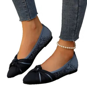 Elegant navy blue knitted pointed toe flat shoes with decorative bow on model feet