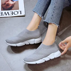 Breathable women's grey fly-knit sneakers in casual Korean style on lifestyle background