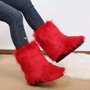 Nahaufnahme der leuchtend roten Kunstpelz-Schneestiefel mit dicker schwarzer Sohle.