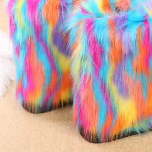 Makro-Detail der lebendigen Regenbogen-Kunstfell-Textur auf stylischen Damen-Schneestiefeln