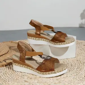 Detailed close-up of metallic bronze wedge sandals with espadrille platform and ring buckle.
