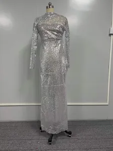 Détail d'une robe longue à paillettes argentées avec décolleté en résille ajourée.