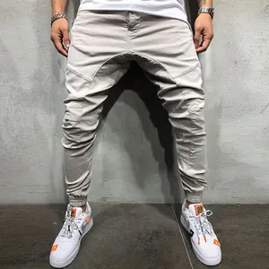 Vista detallada de pantalones cargo beige para hombre con costuras elegantes y bajos elásticos.