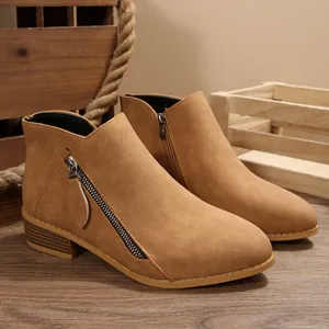 Detailed view of tan faux suede ankle boots with side zipper and chunky low heel