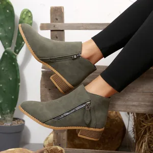 Side view of olive green suede-like ankle boots with functional zipper and low block heel