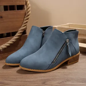 Detail view of blue pointed-toe ankle boots with side zipper and stacked chunky heel.