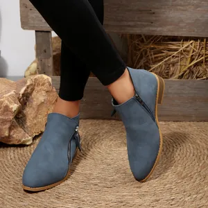 Macro view of blue suede pointed toe ankle boots with metallic side zipper