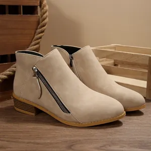 Side view of women's beige suede ankle boots with side zipper and chunky heel