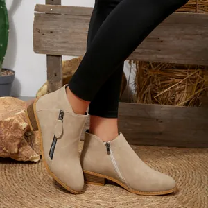Elegant side view of stylish beige pointed-toe ankle boots with side zipper detail.