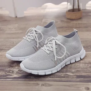 Detailansicht atmungsaktiver grauer Flyknit-Mesh-Damen-Sneaker mit weißen Sohlen.