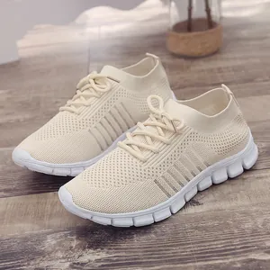Nahaufnahme der atmungsaktiven beigen Flyknit-Sneaker für Damen mit weißer Plateausohle